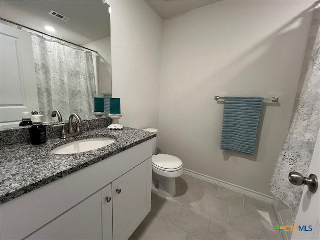 bathroom featuring vanity, tile patterned floors, and toilet