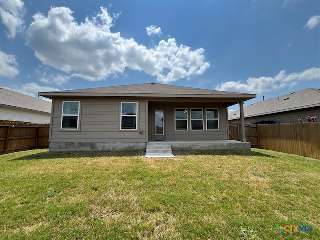 rear view of property with a patio area and a yard