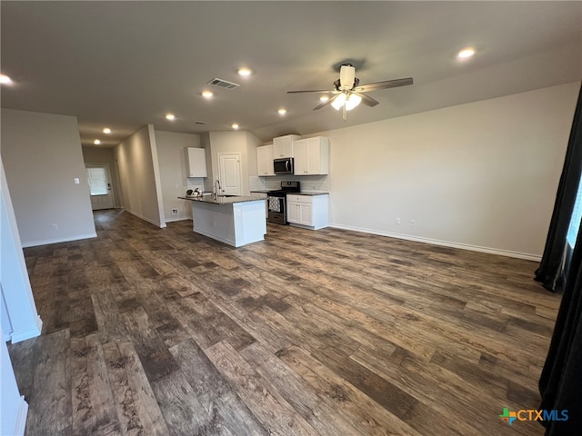 kitchen featuring dark hardwood / wood-style flooring, white cabinets, black / electric stove, sink, and an island with sink