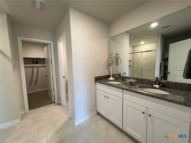 bathroom featuring walk in shower, vanity, and tile patterned floors