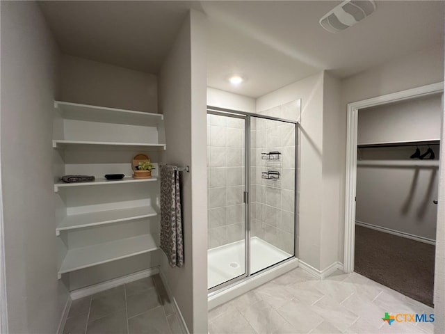 bathroom featuring walk in shower and tile patterned flooring