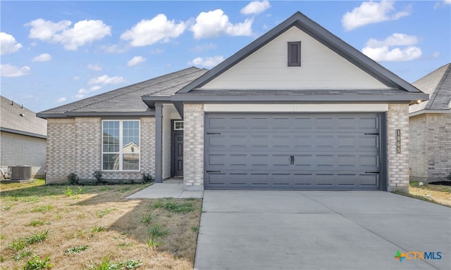 view of front of home featuring a garage and central AC unit