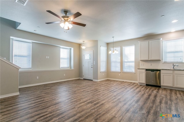 unfurnished living room featuring dark wood-type flooring, ceiling fan with notable chandelier, a textured ceiling, and sink