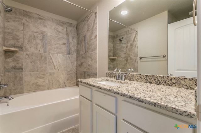 bathroom featuring tiled shower / bath combo and vanity