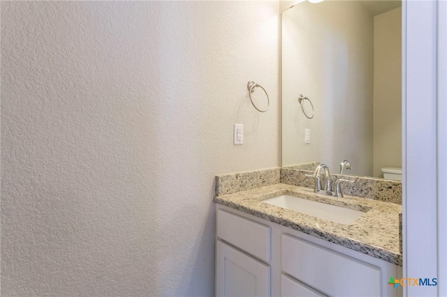 601 Westfield Blvd, Temple, TX 76502 - half bath with vanity, toilet, and a textured wall