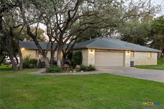 ranch-style home with an attached garage, stone siding, concrete driveway, and a front yard