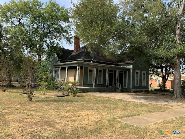 exterior space featuring covered porch and a yard