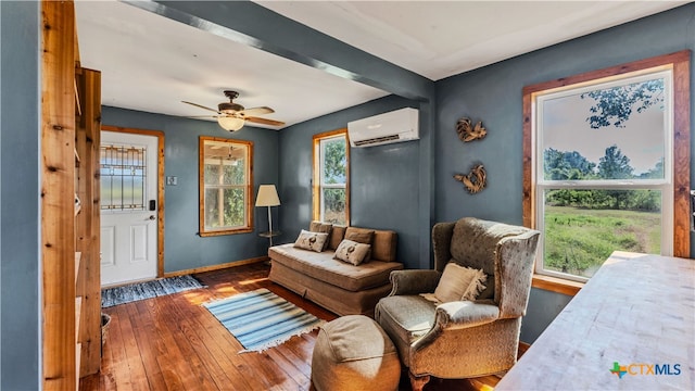 sitting room with a wall unit AC, ceiling fan, and dark hardwood / wood-style flooring