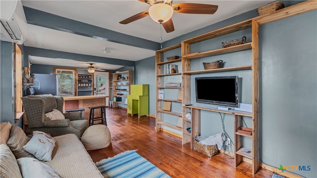 living room with ceiling fan, a wall unit AC, and wood-type flooring