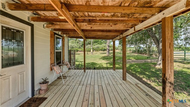 unfurnished sunroom featuring beamed ceiling and wood ceiling