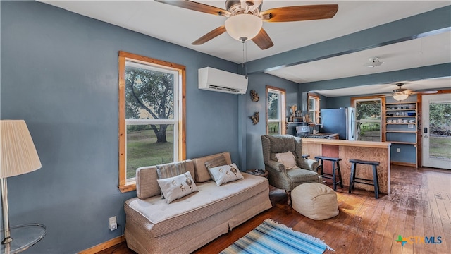 living area featuring ceiling fan, wood-type flooring, and a wall mounted AC