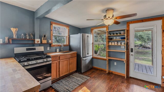 kitchen featuring wooden counters, stainless steel appliances, dark hardwood / wood-style flooring, sink, and ceiling fan