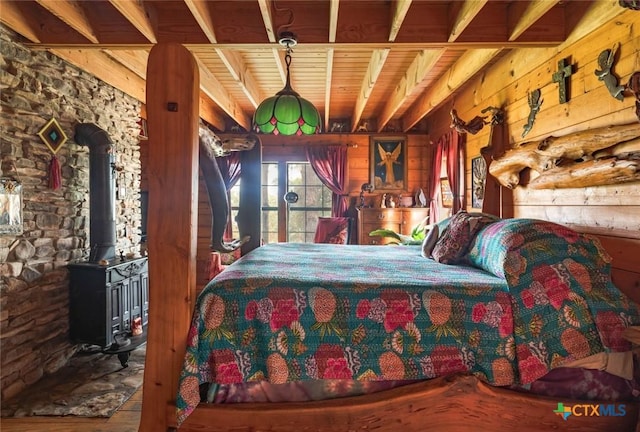 1218 Oakwood Loop, San Marcos, TX 78666 - bedroom featuring a wood stove, wood finished floors, wood ceiling, and wood walls