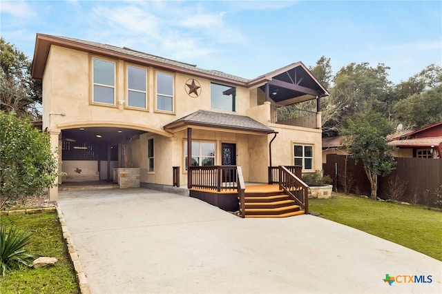 view of front of house with a porch, a balcony, and a front yard