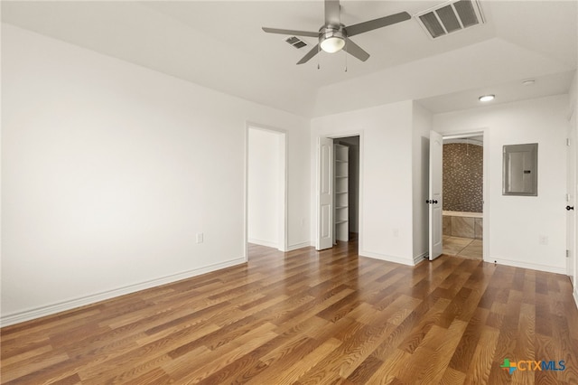 empty room featuring hardwood / wood-style flooring, electric panel, and ceiling fan