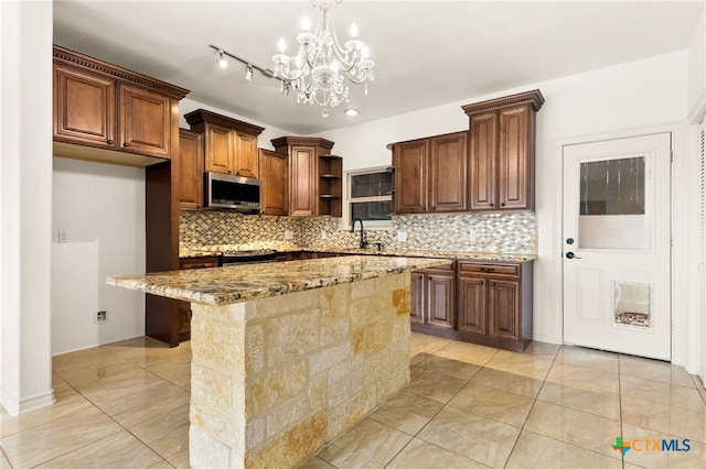 kitchen featuring stainless steel appliances, a center island, a kitchen breakfast bar, light stone countertops, and decorative light fixtures