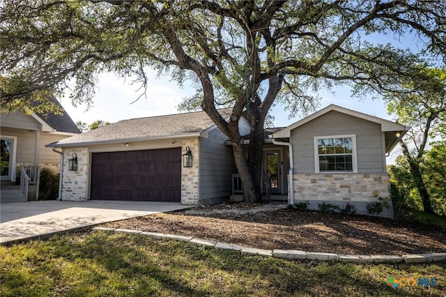 ranch-style house with driveway, stone siding, and a garage