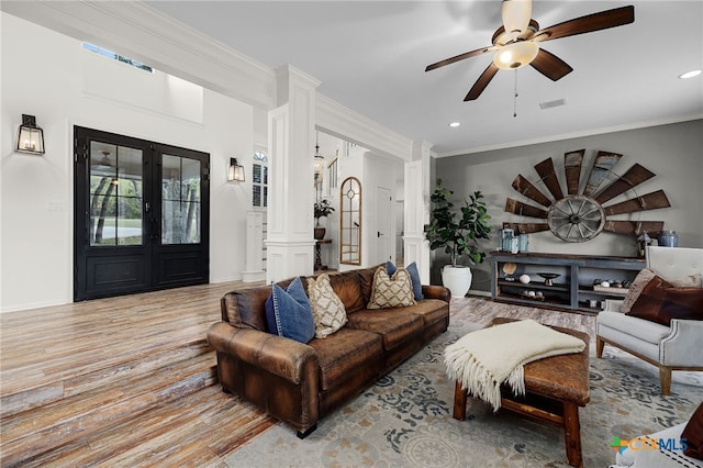 living area featuring crown molding, ceiling fan, recessed lighting, ornate columns, and wood finished floors