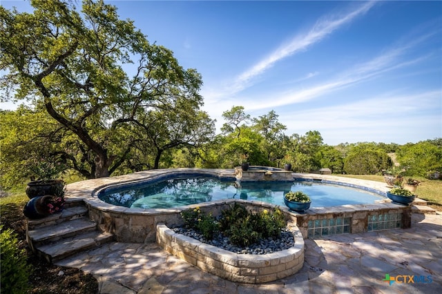 view of pool with a pool with connected hot tub
