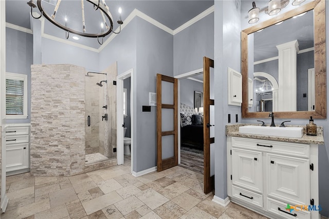 ensuite bathroom featuring a shower stall, stone tile floors, baseboards, ornamental molding, and ensuite bathroom