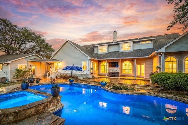 view of swimming pool with a pool with connected hot tub and a patio area