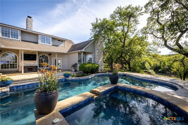 view of swimming pool with a pool with connected hot tub