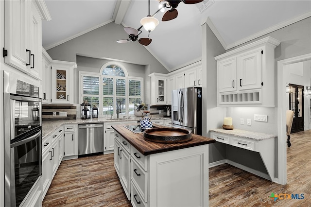 kitchen with butcher block counters, ceiling fan, stainless steel appliances, and white cabinetry