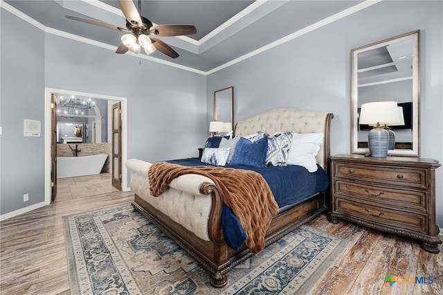 bedroom with ceiling fan with notable chandelier, baseboards, ornamental molding, wood finished floors, and ensuite bathroom