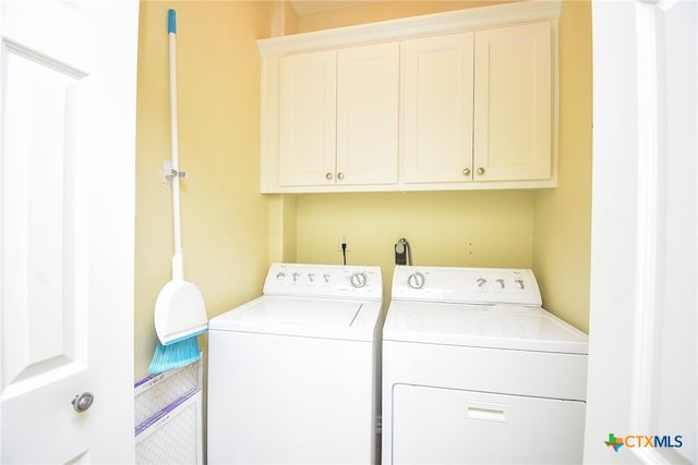 laundry area with washing machine and dryer and cabinets