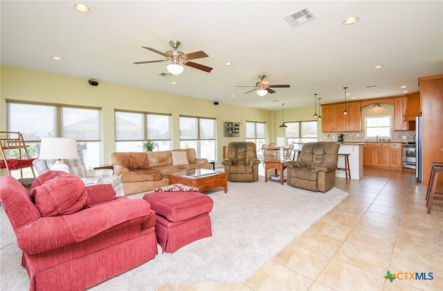 living room with plenty of natural light, ceiling fan, and light tile patterned floors