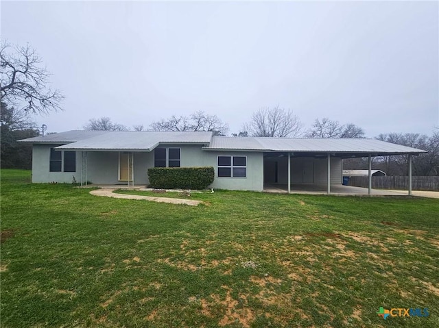 rear view of house featuring a lawn and a carport