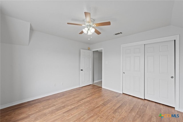 unfurnished bedroom with lofted ceiling, light hardwood / wood-style flooring, a closet, and ceiling fan