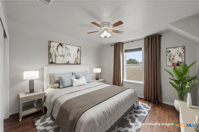 bedroom featuring ceiling fan, dark hardwood / wood-style flooring, and vaulted ceiling