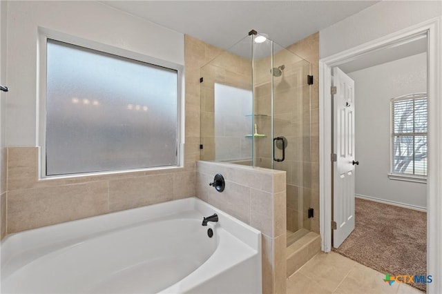 bathroom with tile patterned flooring and separate shower and tub