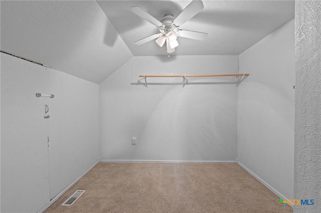 spacious closet featuring vaulted ceiling, ceiling fan, and carpet flooring