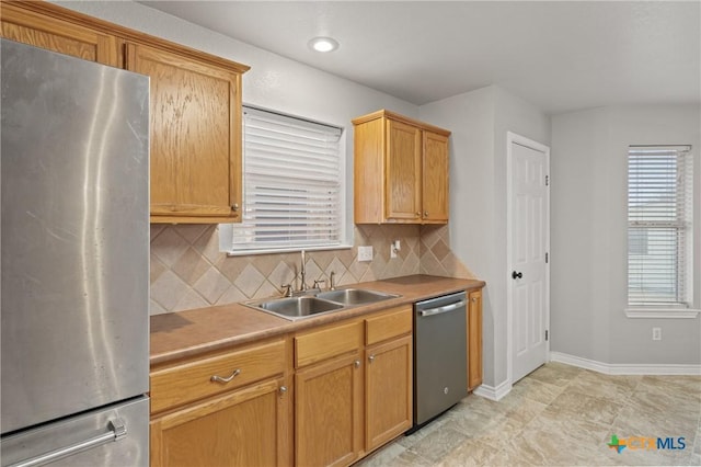 kitchen with sink, decorative backsplash, and stainless steel appliances