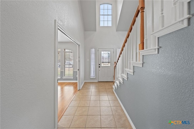 tiled foyer featuring a towering ceiling