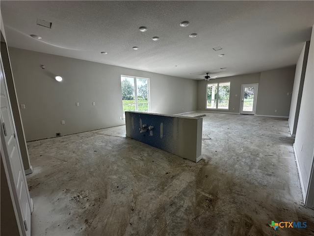 kitchen with white cabinetry, a textured ceiling, ceiling fan, and a center island