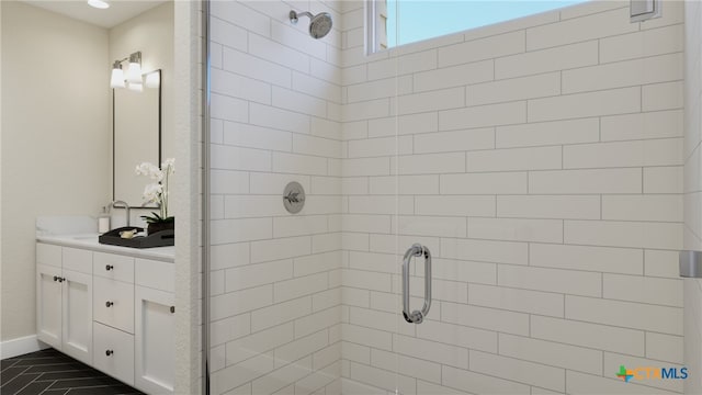 bathroom with a shower with shower door, vanity, and tile patterned floors