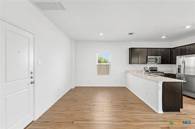 383 Soapstone Pass, San Marcos, TX 78656 - kitchen with stainless steel appliances, light countertops, light wood-style flooring, a sink, and recessed lighting
