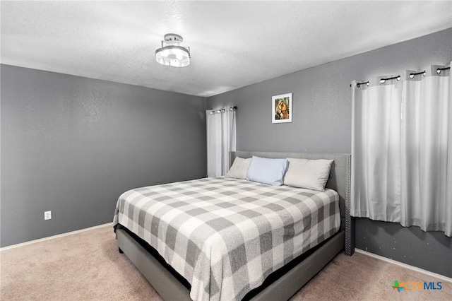 bedroom featuring light carpet and a textured ceiling