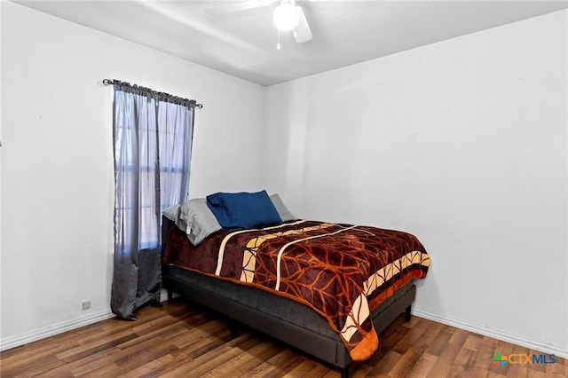 bedroom with dark hardwood / wood-style floors and ceiling fan