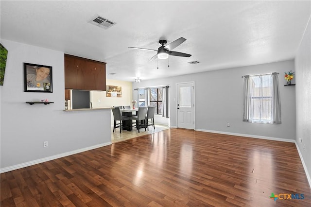 unfurnished living room featuring hardwood / wood-style flooring, a wealth of natural light, and ceiling fan