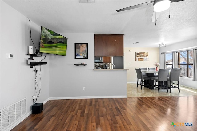 living room with dark hardwood / wood-style floors and ceiling fan