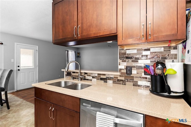 kitchen featuring sink, stainless steel dishwasher, light stone counters, and decorative backsplash