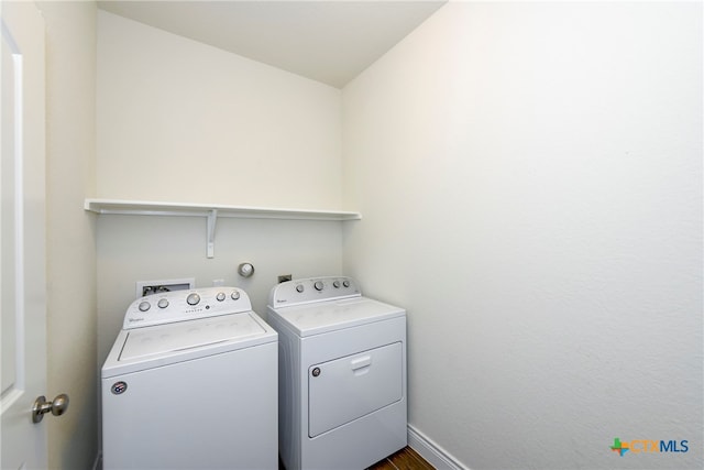 clothes washing area featuring dark hardwood / wood-style floors and washer and dryer