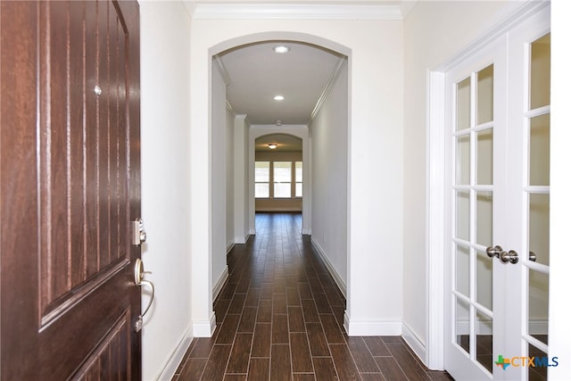 hallway with ornamental molding and dark wood-type flooring