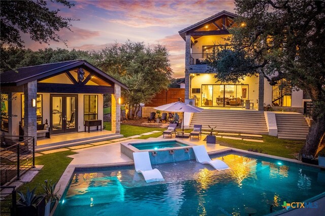 115 Steeplechase, New Braunfels, TX 78132 - rear view of property with metal roof, a standing seam roof, concrete driveway, and stucco siding