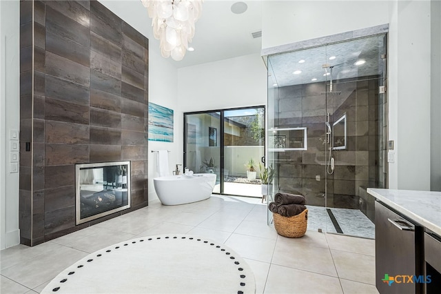 bathroom featuring tile patterned flooring, shower with separate bathtub, vanity, and a fireplace