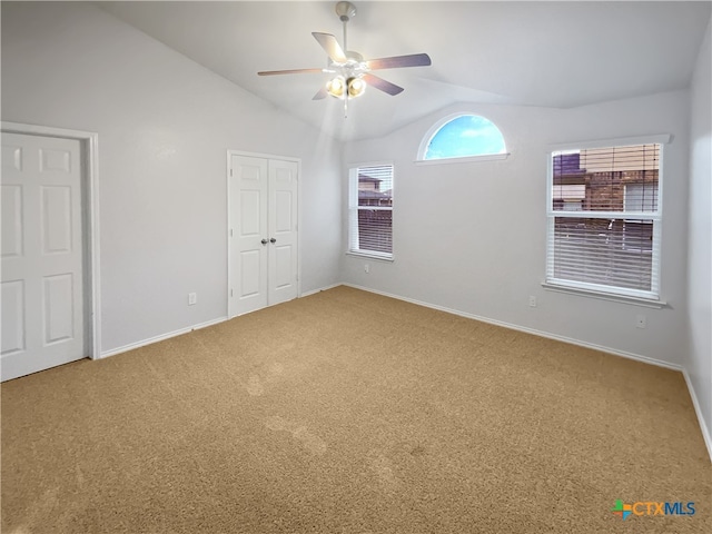 unfurnished bedroom featuring carpet, lofted ceiling, and ceiling fan